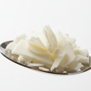 flaked soy wax on a spoon 